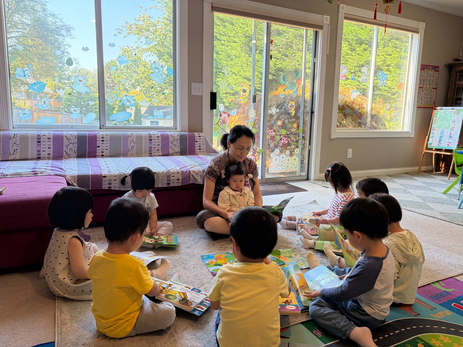 Teacher Ma reading with a group of children in the daycare classroom